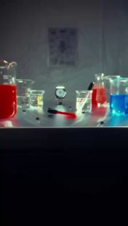 Лабораторный стол с колбами и разноцветными жидкостями, на фоне маленьких часов; кадр создаёт ощущение арт‑эксперимента и процесса.