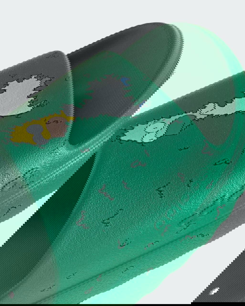 Макрофрагмент верхней части слайда adidas с ярким принтом Гомера и рельефным логотипом на боковой части изделия; акцент на отделке и фактуре.