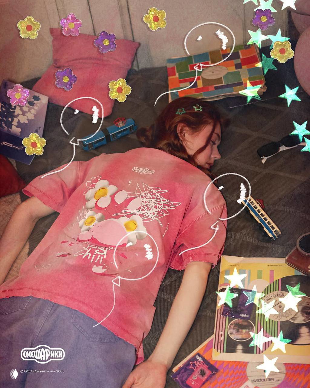Модель лежит на диване в розовой футболке с принтом Бегемота; кадр стилизован с наклейками и передаёт атмосферу мерча для молодёжи.