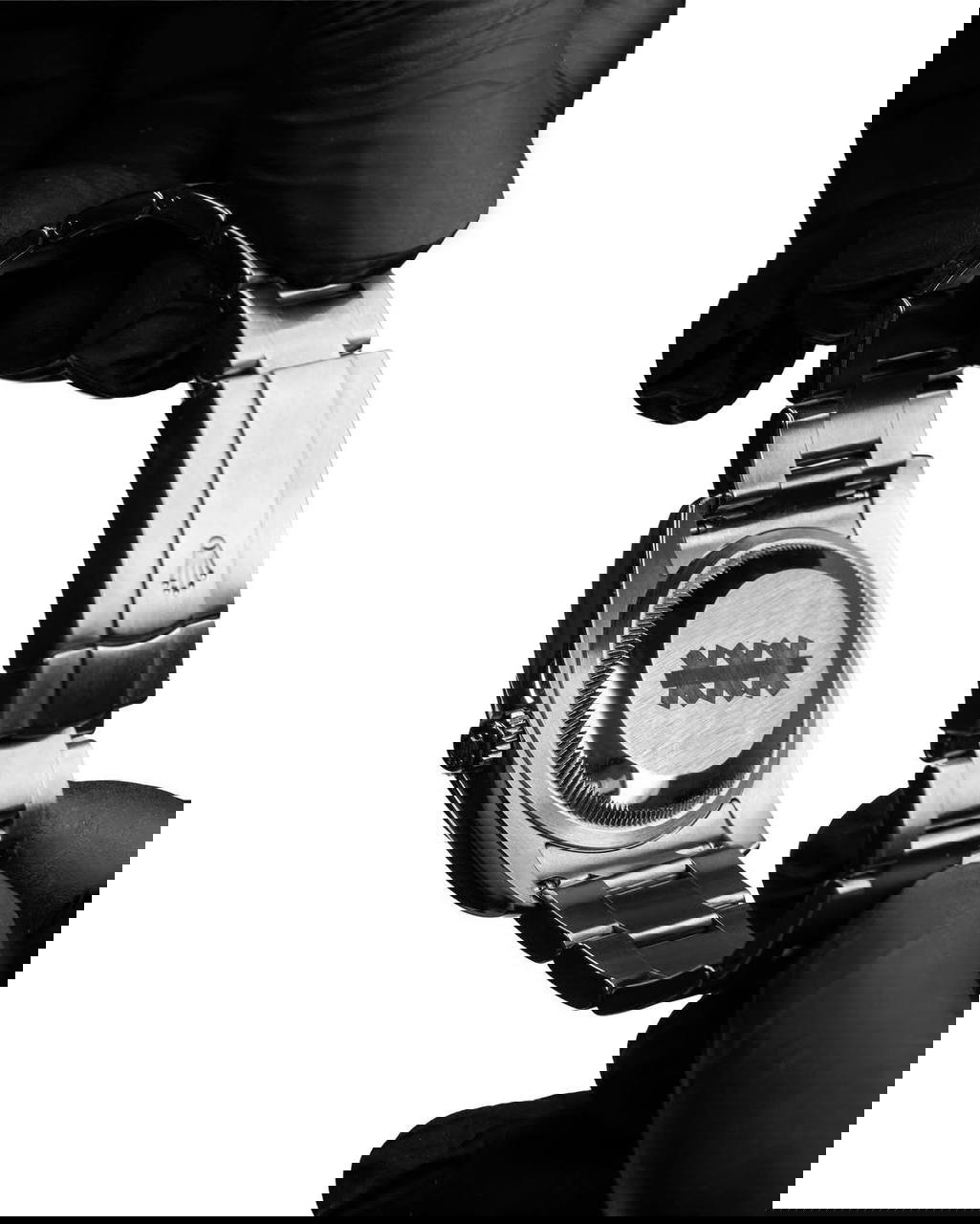 Чёрно‑белый кадр: задняя крышка и браслет Rolex в руках в перчатках — показывают состояние и гравировку обратной стороны часов.