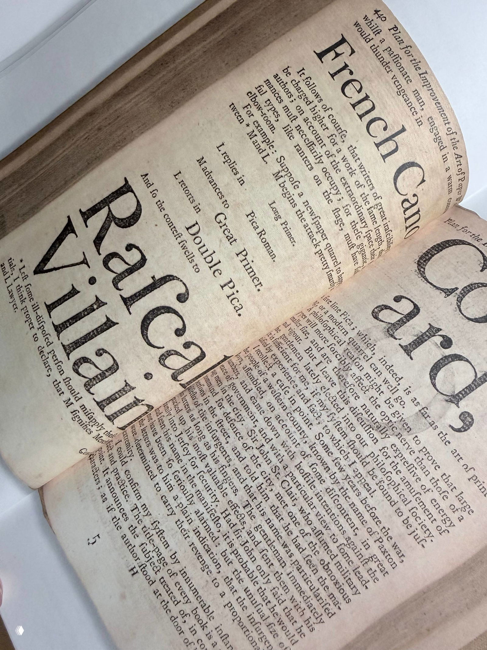 Разворот книги с примерами шрифтов и старинной типографики; крупные названия и плотный набор текста на состаренной бумаге.