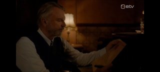 Мужчина в тёмной комнате читает письмо у лампы; тёплый свет и интерьер подчёркивают атмосферу и тему внутренней перемены.