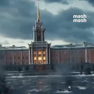 Здание с высокой колокольней на фоне драматичного неба; кадр из видеоролика с логотипом mash, городской пейзаж в сумрачной атмосфере.