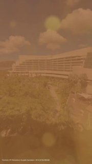 Фото курортного отеля на тропическом Хайнане: корпус отеля, зелёная территория и пальмы на фоне тёплой солнечной погоды.