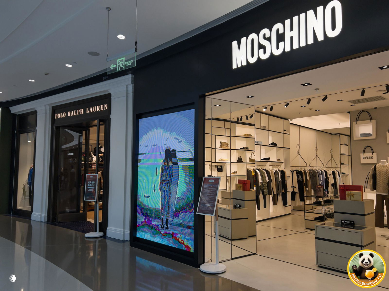 Внутренний коридор торгового центра с бутиками Polo Ralph Lauren и Moschino: витрины, цифровой экран и полированный пол.