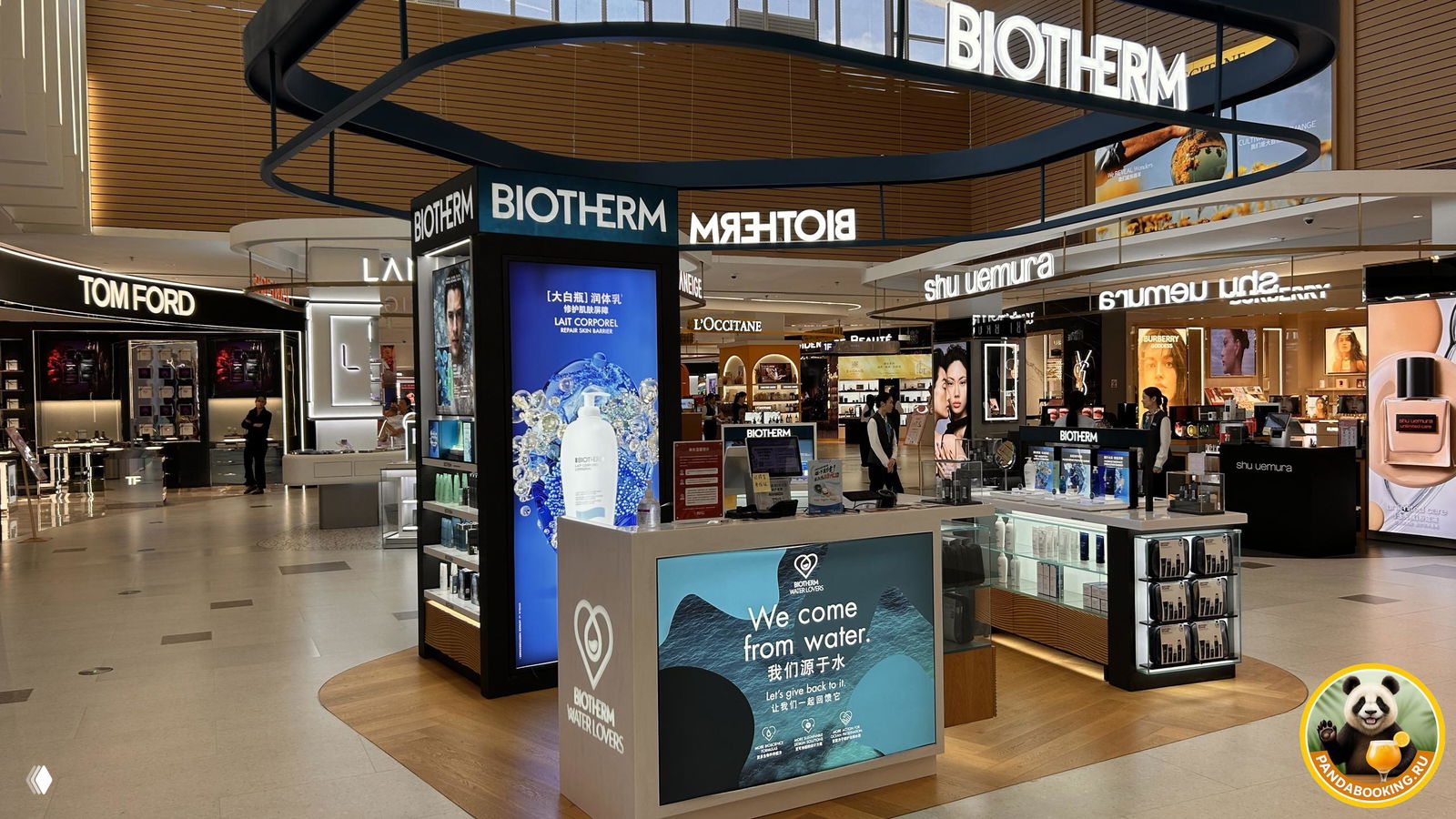 Внутренний вид торгового зала Duty Free с островками Biotherm, стойками Shu Uemura и магазинами Tom Ford, просторный современный интерьер.