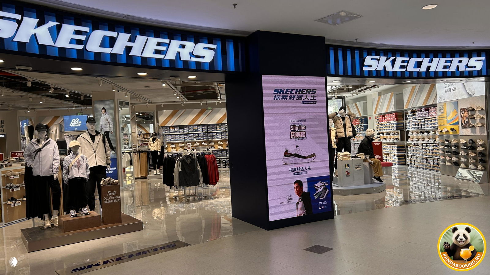Магазин Skechers в Duty Free с яркой неоновой вывеской, витрины с обувью и просторный пол перед входом в магазин.
