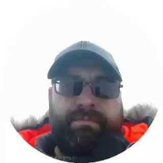 Портретное селфи автора публикации в тёплой куртке, кепке и очках на фоне неба после выезда на рыбалку, лицо видно в круглом кадре.