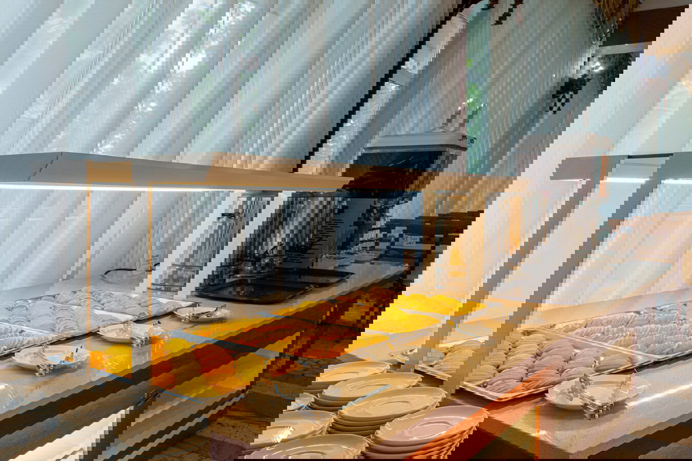 Буфетный стол со свежими нарезанными фруктами и напитками в столовой санатория, организация питания для гостей во время курсового лечения.