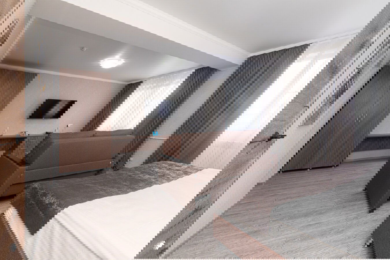 Типовой номер санатория с кроватью, диваном и рабочей зоной у окна — пример комфортного размещения для отдыха и восстановления после процедур.