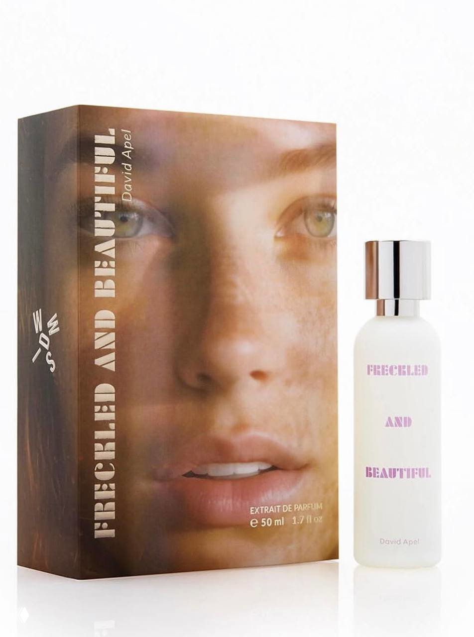 Флакон и коробка аромата Freckled and Beautiful: белый матовый флакон с надписью и коробка с портретом на светлом фоне.