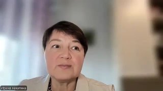 Крупный план женщины во время видеобеседы, размытый нейтральный фон, спокойное выражение лица, элегантный пиджак.