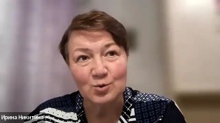 Женщина в кадре во время видеозаписи: крупный план лица, мягкое освещение и нейтральный фон, кадр из онлайн-эфира.