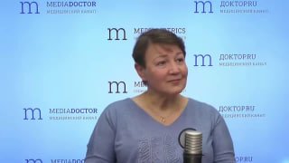 Женщина в радиостудии перед микрофоном на фоне логотипов Mediametrics и ДокторПРО: интервью о телесных реакциях и работе лимбической системы.