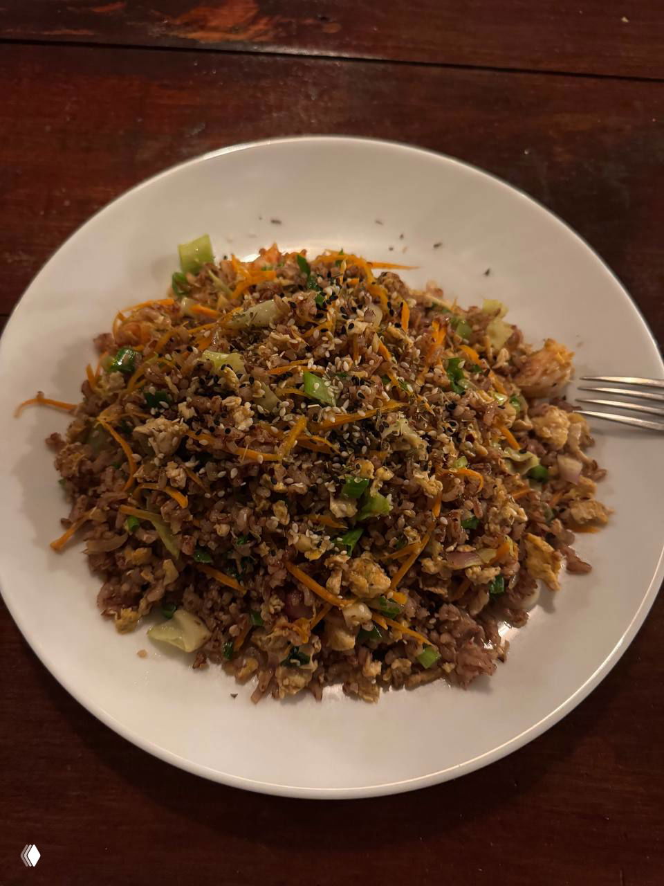 Тарелка жареного риса с креветками на деревянном столе в тёплом освещении — недорогая и сытная уличная еда на Шри-Ланке.