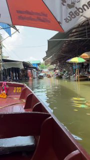 Вид с лодки на канал плавучего рынка: лодки, навесы и прилавки вдоль воды, отражения в канале и суматошная торговая обстановка. Фото автора.