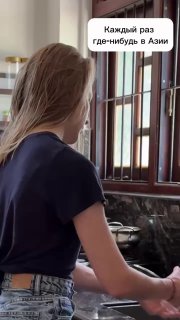 Автор в интерьере кафе или общественного места в Азии, кадр с текстовым стикером «Каждый раз где-нибудь в Азии», атмосферный момент поездки.