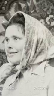 Чёрно-белый портрет женщины в платке, улыбающаяся в профиль; тёплая домашняя обстановка и ностальгическое настроение воспоминаний.