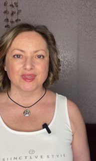 Портрет автора NataZam в светлой майке с кулоном и петличным микрофоном, крупный план; кадр из видео с прочтением дебютного стихотворения.