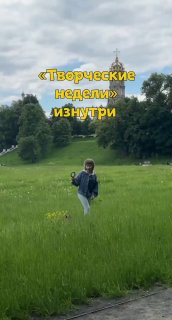 Ребёнок идёт по высокому зелёному полю во время прогулки с видом на церковь и деревья; на фото заголовок «Творческие недели».