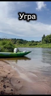 Песчаный берег Угры с надувным каяком у линии воды, спокойное течение и пологая прибрежная полоса перед сплавом по реке летом.