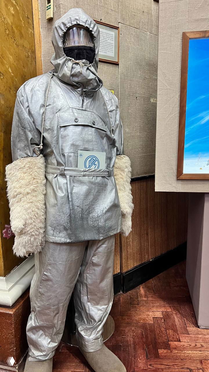 Манекен в серебристом полярном костюме с меховыми манжетами и балаклавой — музейный образ экипировки для экстремального холода.