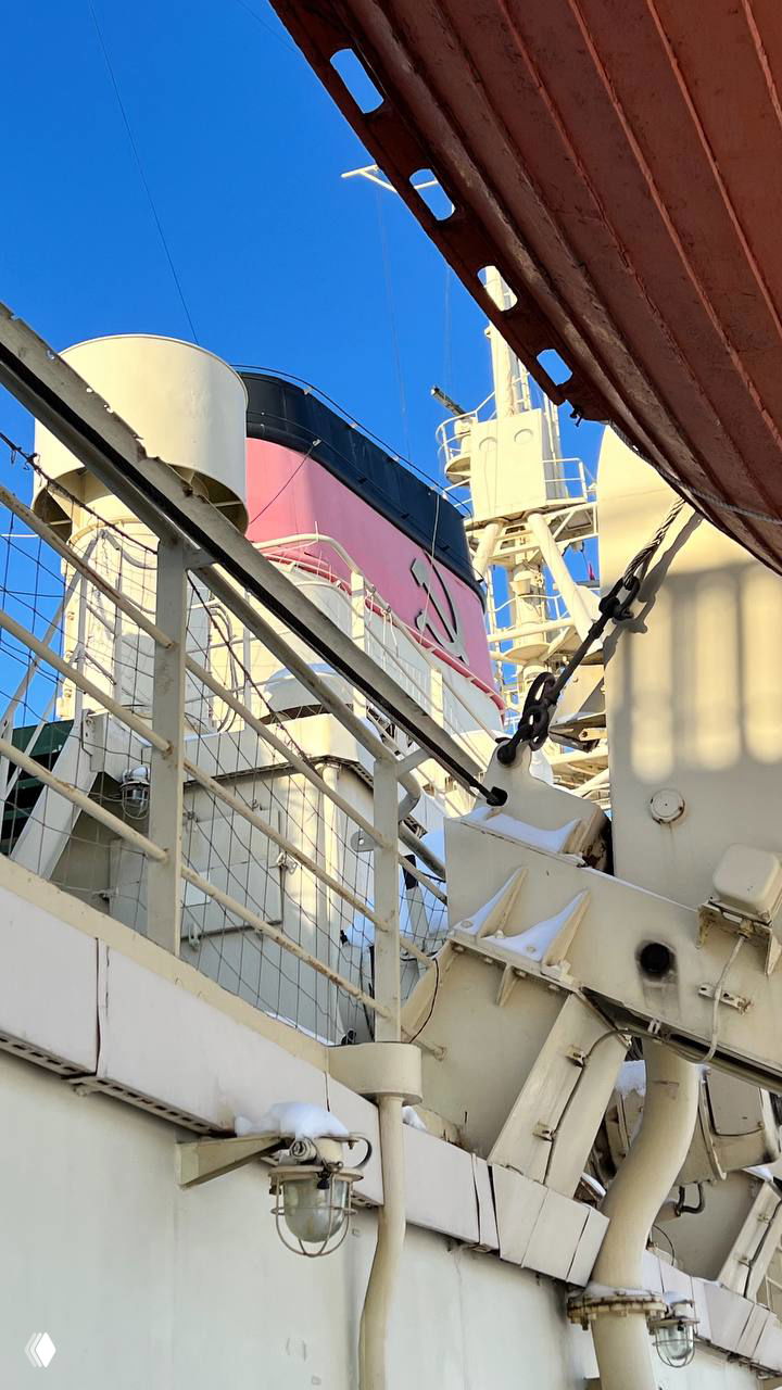 Детали палубного оборудования и трубы ледокола «Красин»: ригели, поручни и элементы спасательного снаряжения на фоне небесно-голубого неба.