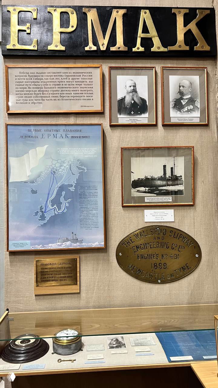Витрина, посвящённая ледоколу «Ермак»: табличка с названием, архивные фотографии и памятные таблички из истории полярных экспедиций.