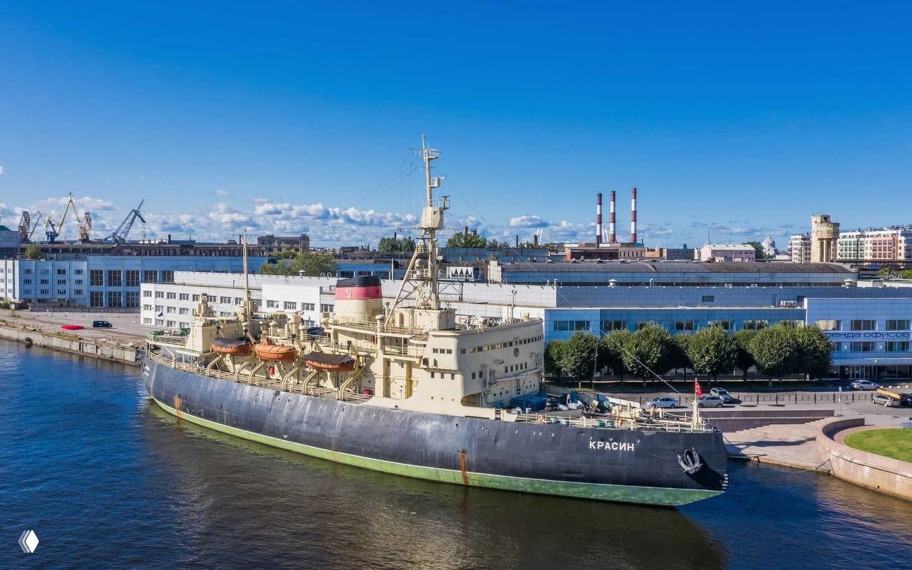 Ледокол «Красин» пришвартован у набережной: серо‑черный корпус, палубное оборудование и портовая инфраструктура на заднем плане.