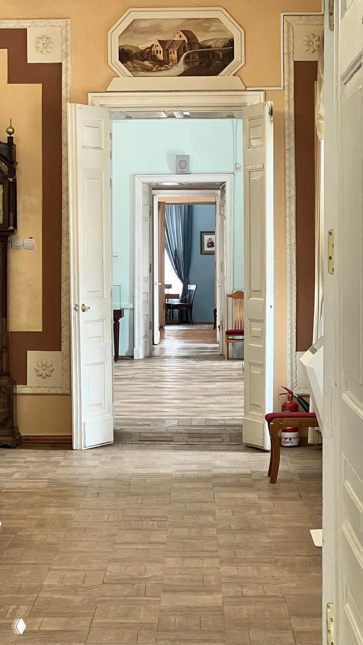 Интерьер усадебного дома: открытые двери и коридоры, перспектива нескольких комнат с паркетом и лепниной на стенах в музее усадьбы