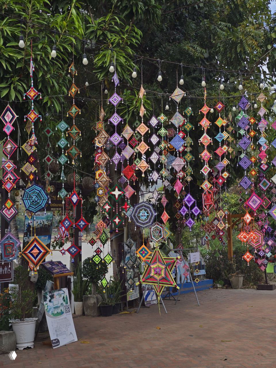 Многоцветные подвесные декоративные плетёные украшения и звёздные инсталляции на площади или уличном рынке — яркий локальный хэндмейд и атмосфера ремесел.