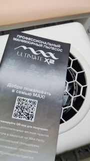 Крупный план коробки настольного пылесоса MAX Ultimate X2 с логотипом, QR‑кодом и видимой сотовой решёткой на фоне рабочего стола.