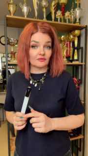 Елена Шалырина держит пылесос MAX Ultimate X2 в маникюрной студии на фоне трофеев — кадр из демонстрационного теста устройства.