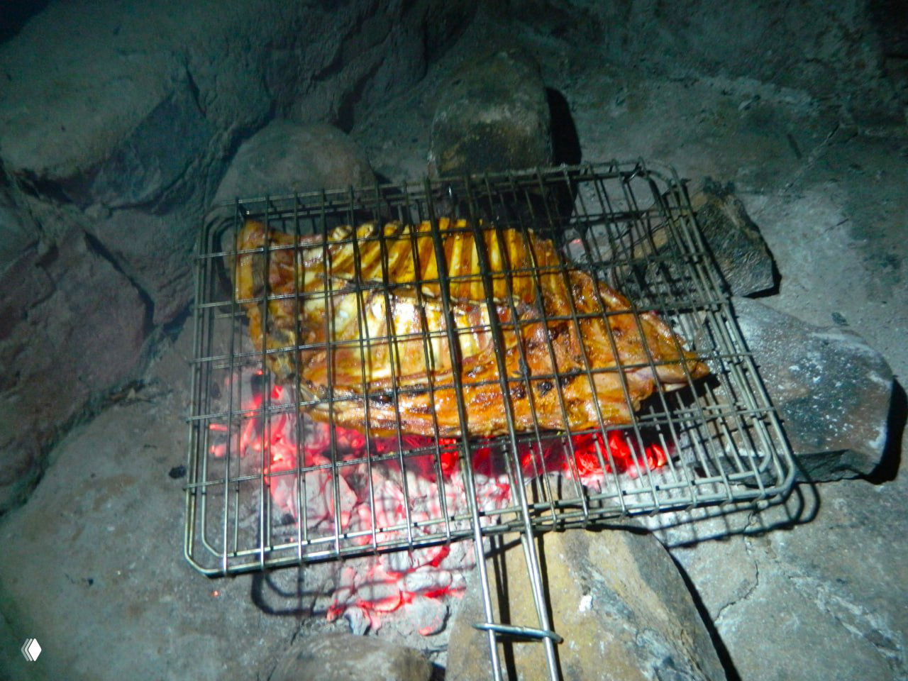 Мясо на решетке над раскалёнными углями в оборудованном месте для костра — способ приготовления, который часто встречается в кемпингах ЮАР и Намибии.