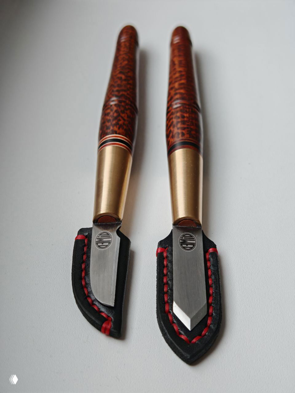 Два ножа сбоку: вид рукоятей из снейквуда с характерным рисунком и латунными переходами к лезвию, симметричный ракурс