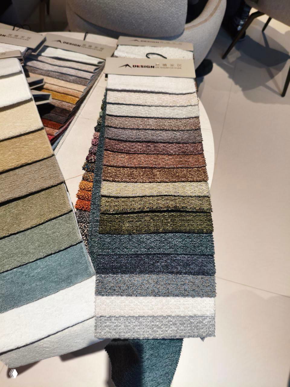 Палитра образцов тканей букле — полоски в натуральных оттенках: песок, влажный камень, коричневые и зелёные меланги с видимой текстурой.