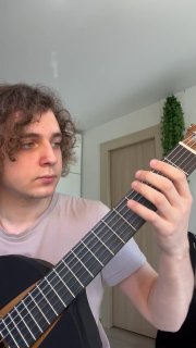 Портретный кадр музыканта с гитарой, видно положение пальцев и гриф — кадр показывает подготовку к экспериментальному строю с фа-диезом.