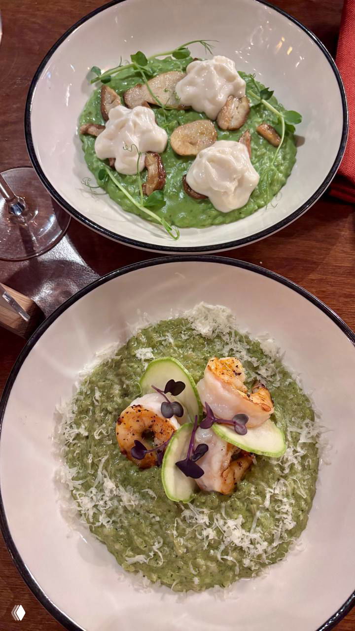 Две тарелки зелёного ризотто с морепродуктами и сырной стружкой — аккуратная подача и примеры блюд, сочетающихся с дегустацией вина.