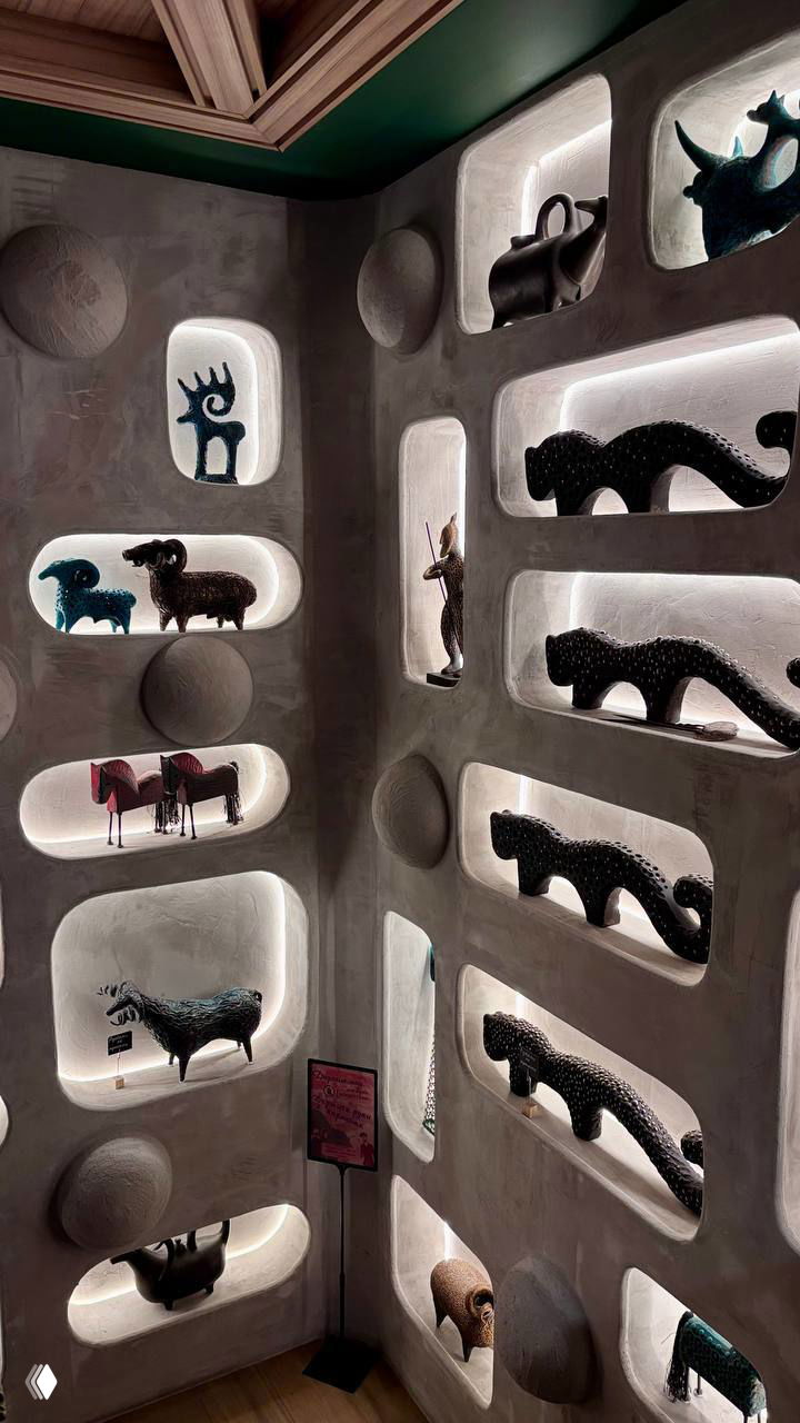 Ниши в стене ресторана, подсвеченные изнутри, заполненные футуристичными и смешными керамическими скульптурами разных животных и форм.