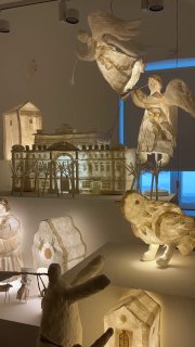 Общий вид инсталляции с парящими ангелами, домиками и миниатюрами — праздничная и сказочная атмосфера выставки «Другая песенка».