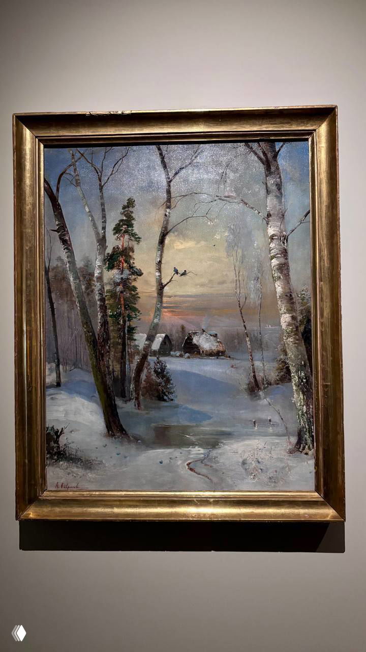 Фотография в раме картины русских пейзажистов: зимний пейзаж с избушкой, берёзами и мягким вечерним светом на полотне, экспозиция в музее.
