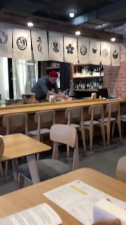 Короткий видеокадр: повар за барной стойкой готовит блюда, видна рабочая зона и техника, съемка в интерьере Shokunin.