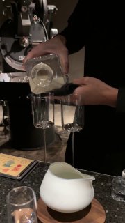 Бариста аккуратно наливает жидкость в мерную ёмкость в процессе приготовления: акцент на технике заваривания и прозрачных сосудах.