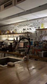 Интерьер кухни-острова: рабочая зона шефа с посудой и оборудованием, ощущение маленькой открытой кухни-гаража в ресторане.