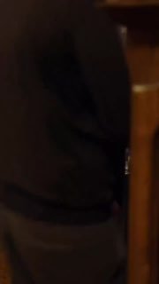 Размытое вертикальное видео с кадром официанта или посетителя со спины у стойки, тёмные тона и деревянные элементы интерьера видны в кадре.