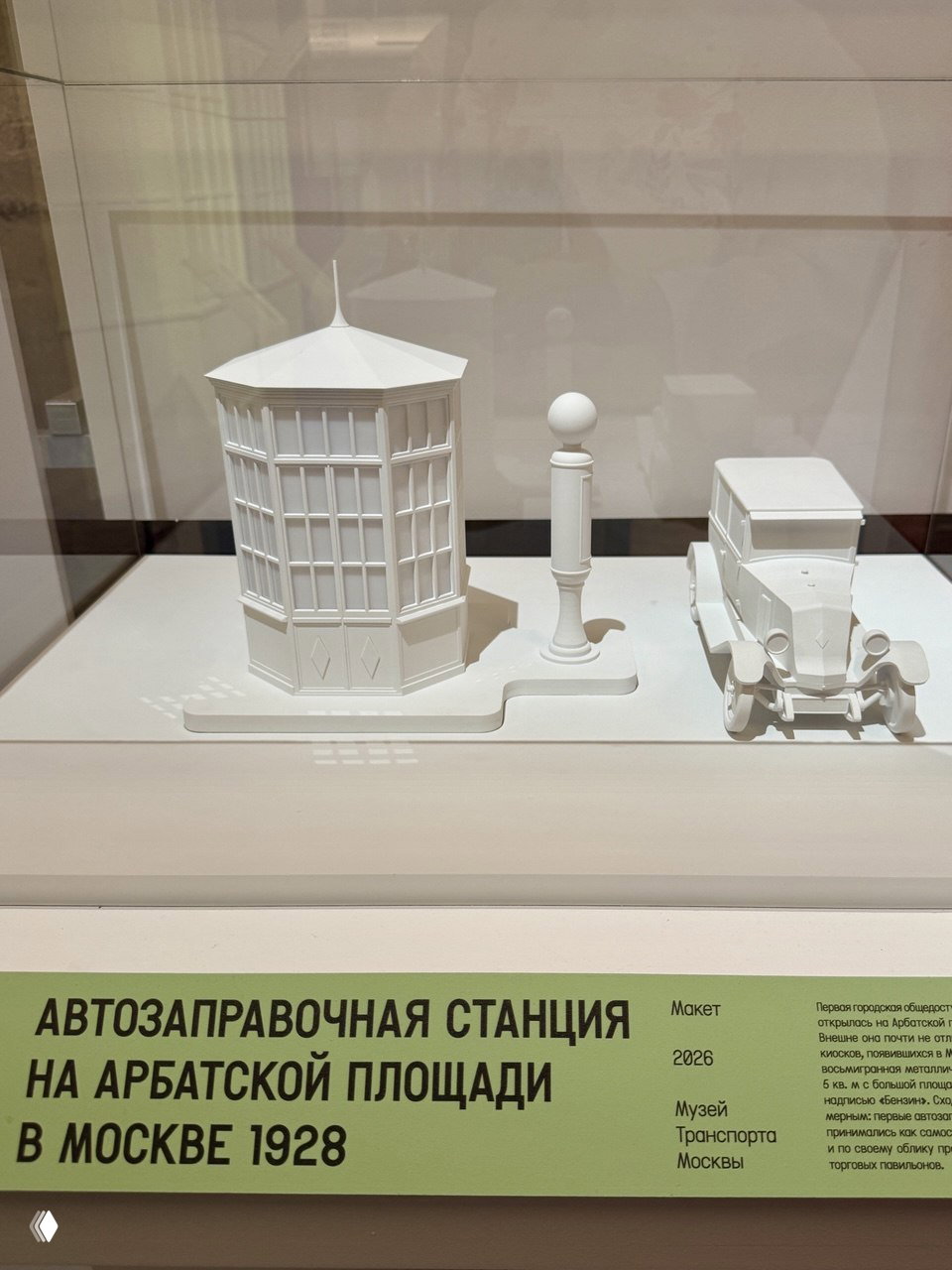 Макет автозаправочной станции на Арбатской площади (1928): белая миниатюра с колонкой и ретро-автомобилем в музейной витрине.