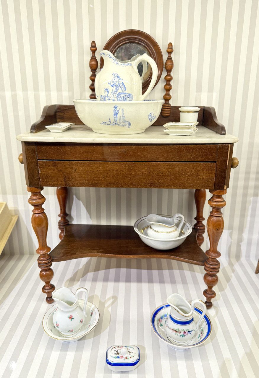 Миниатюрный буфет с керамической умывальной чашей и набором посуды на полочке — предметы мебели и сервизы для кукольного интерьера.