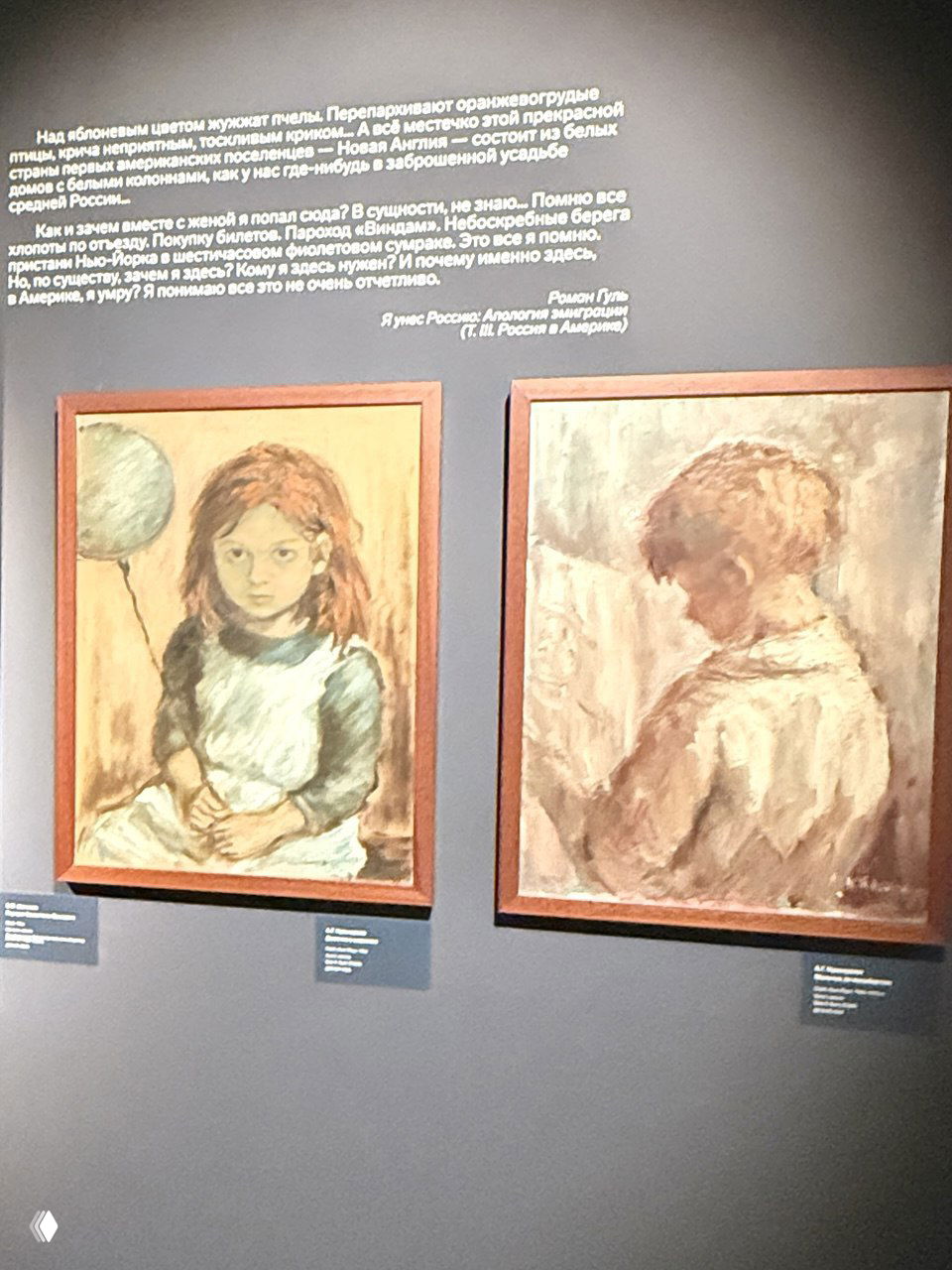 Тёмная стена с двумя картинами и текстом музейной экспозиции над ними: портреты детей и цитаты сопровождения выставки.