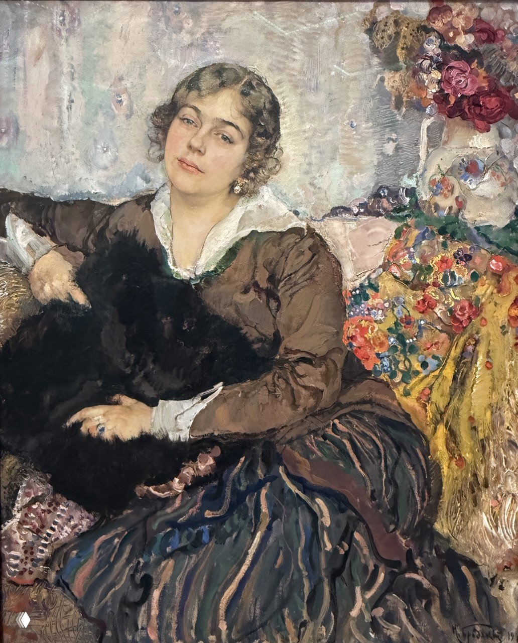 Портрет женщины в интерьере с декоративной тканью и цветами позади; выразительная манера письма, внимание к лицу и текстурам одежды.