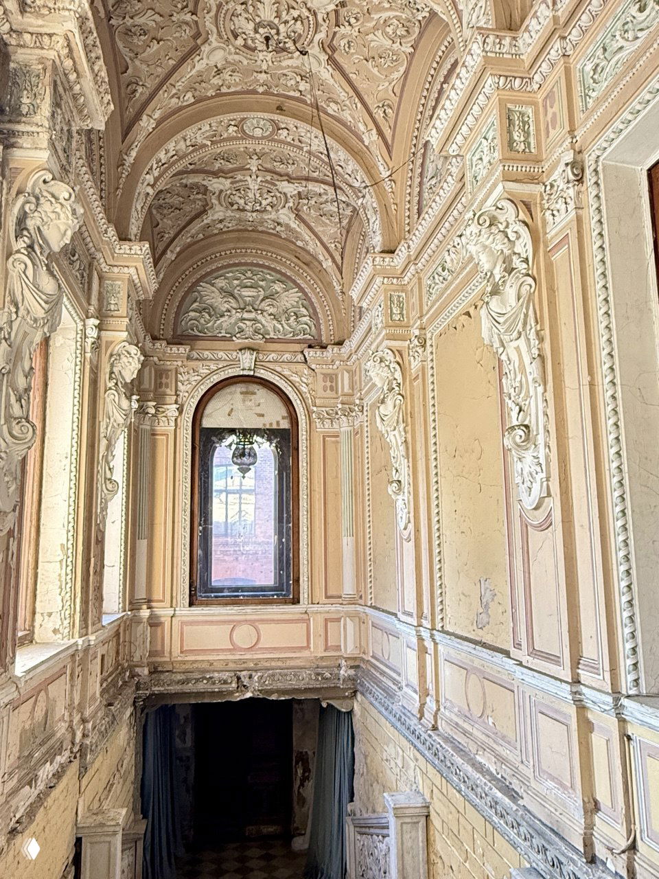 Парадная лестница и декоративные арки особняка Брусницыных с виртуозной лепниной на стенах и сводах, вид сверху вниз.